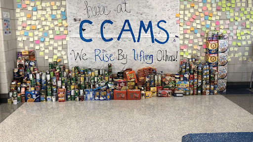The collection of collected food drive items in the middle school cafeteria.